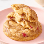 Two strawberry cheesecake cookies with one split in half.