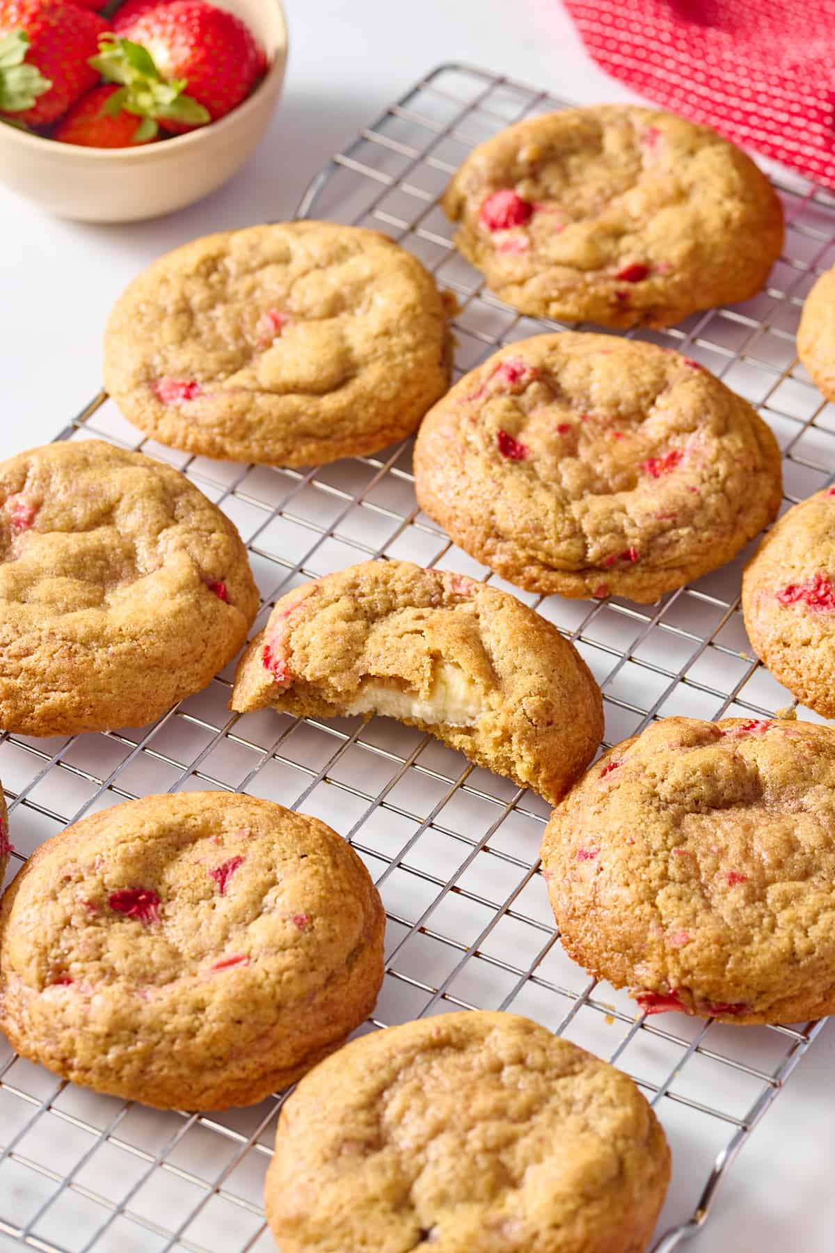 strawberry cheesecake cookies sitting on a wire cooling rack. 