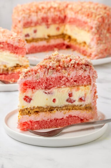 A slice of layered strawberry shortcake cheesecake.
