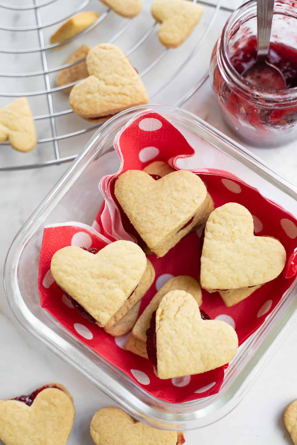 close up image of valentine's day cookies packed in a themed glass container. 