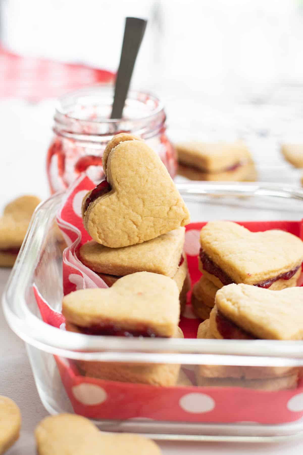 close up image of valentine's day cookies packed in a themed glass container. 