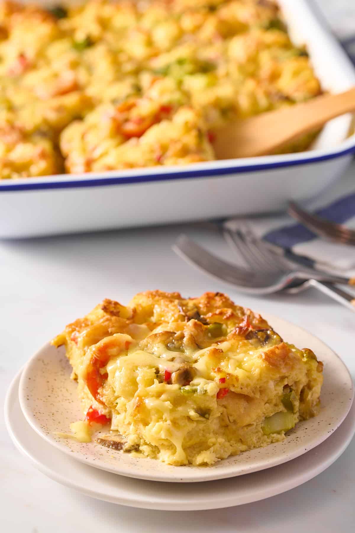 serving of vegetarian breakfast casserole sitting on a stack of two plates. 