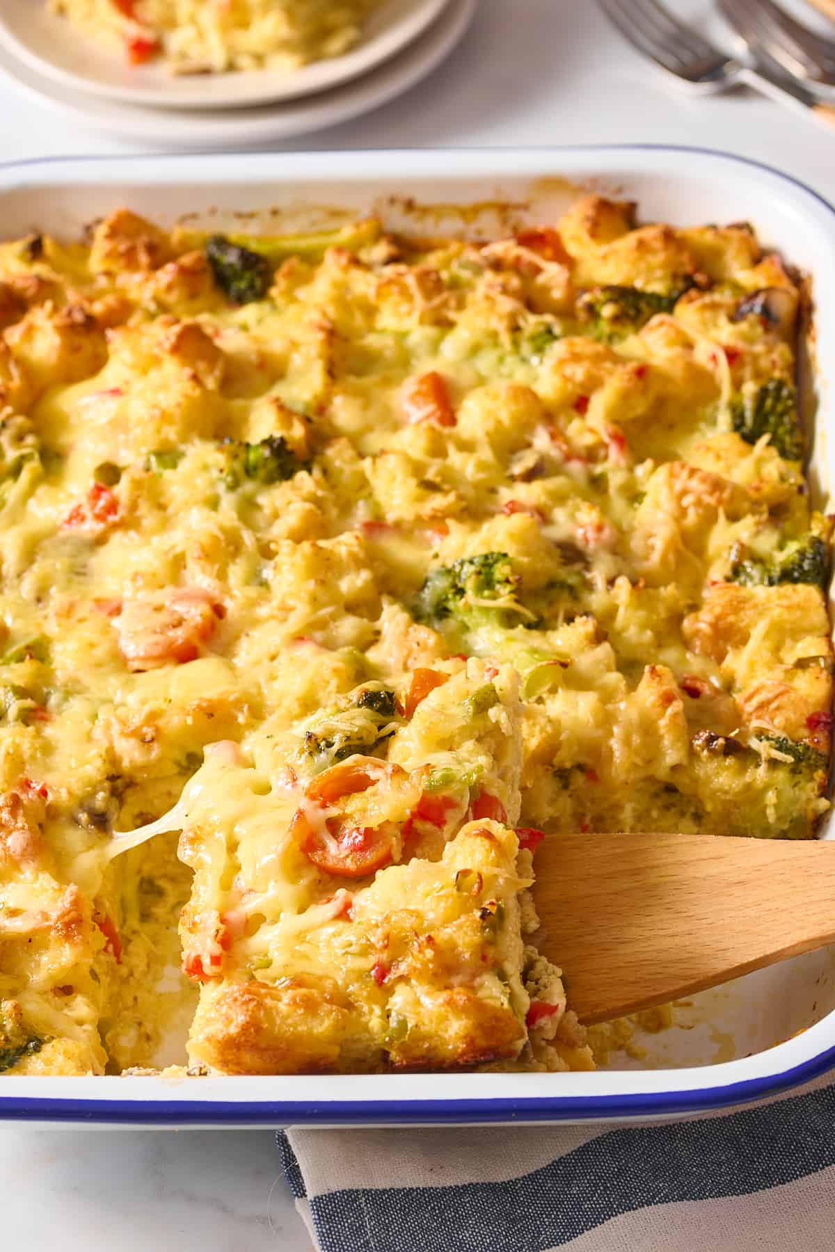 close up image of a wooden spatula digging into a serving of vegetarian breakfast casserole. 