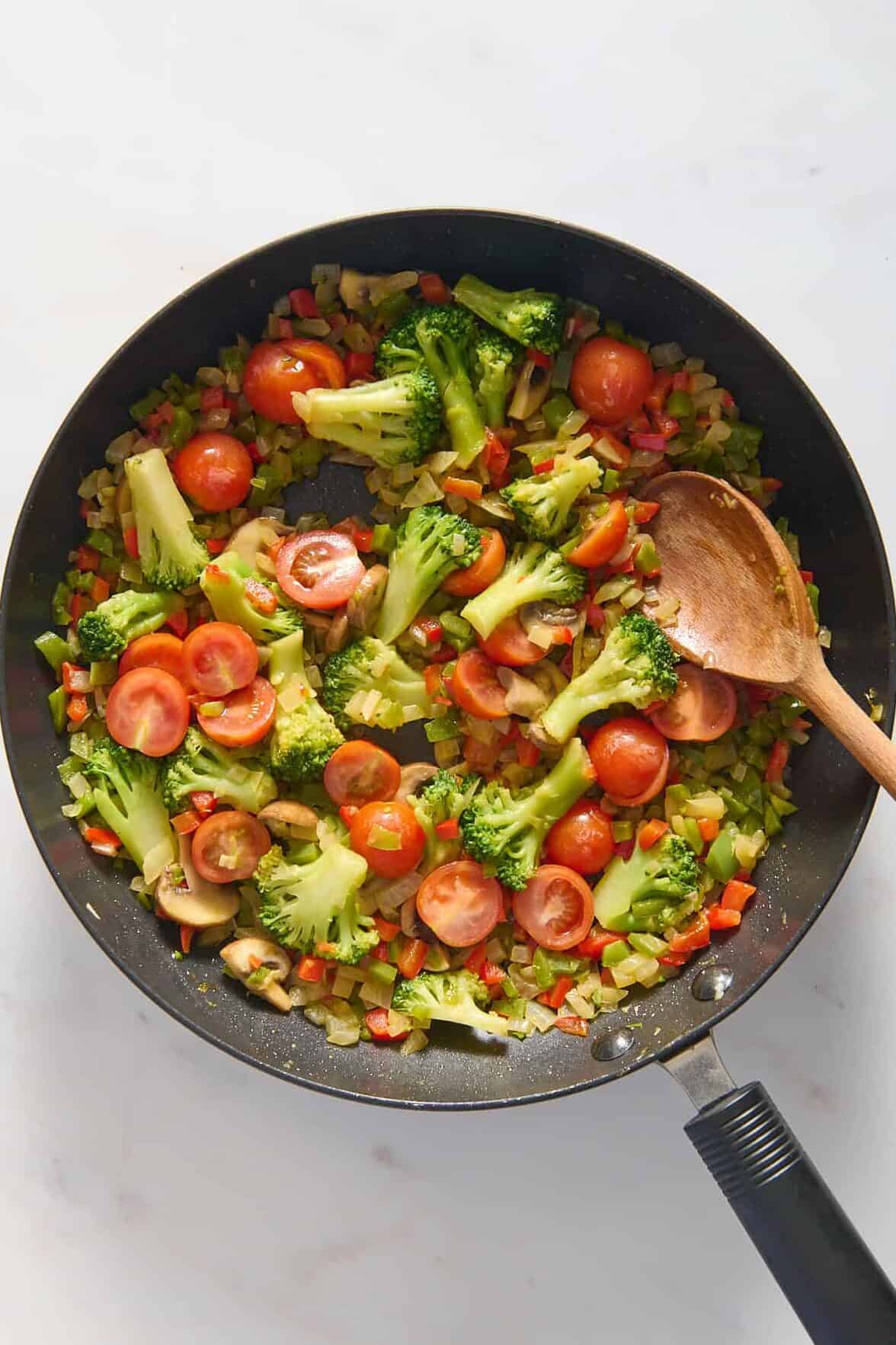 top down image of prepped vegetarian breakfast casserole ingredients sitting a large skillet. 