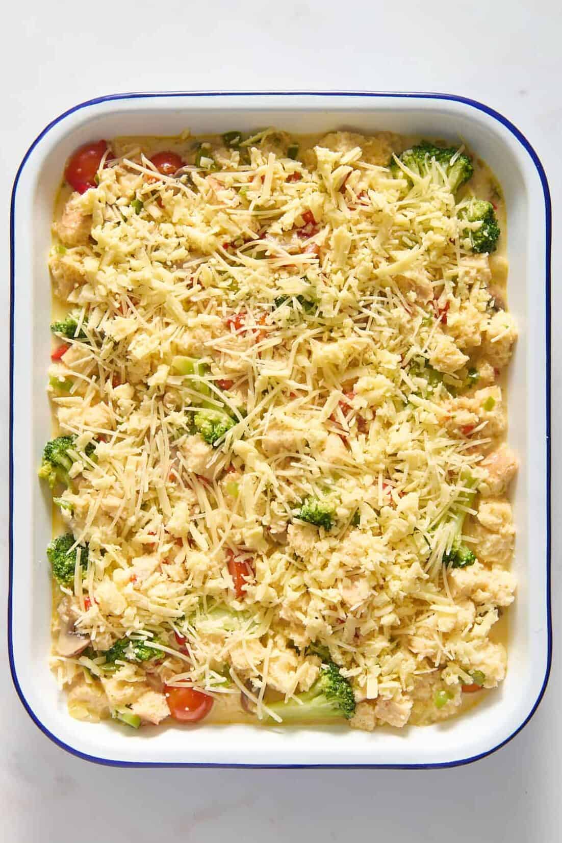 top down image of prepped vegetarian breakfast casserole in a 9x13 inch baking pan. 