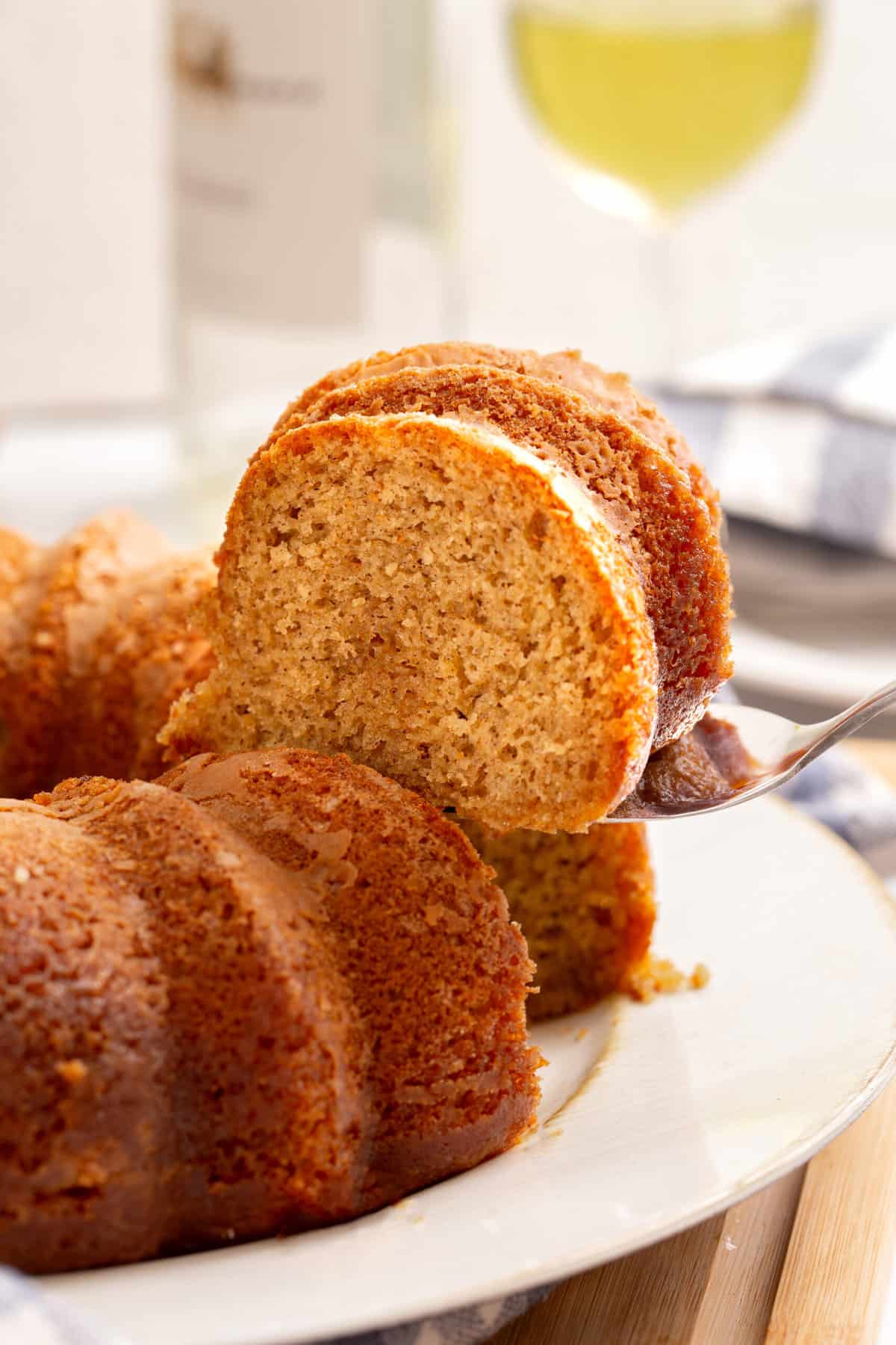 close up image of a slice of crack bundt cake sitting on a metal cake spatula. 