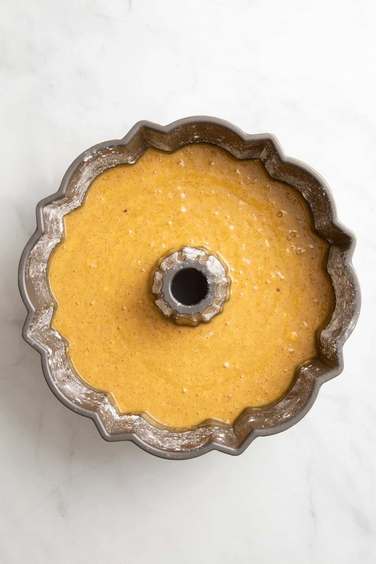 crack cake batter prepared in a bundt cake tin. 