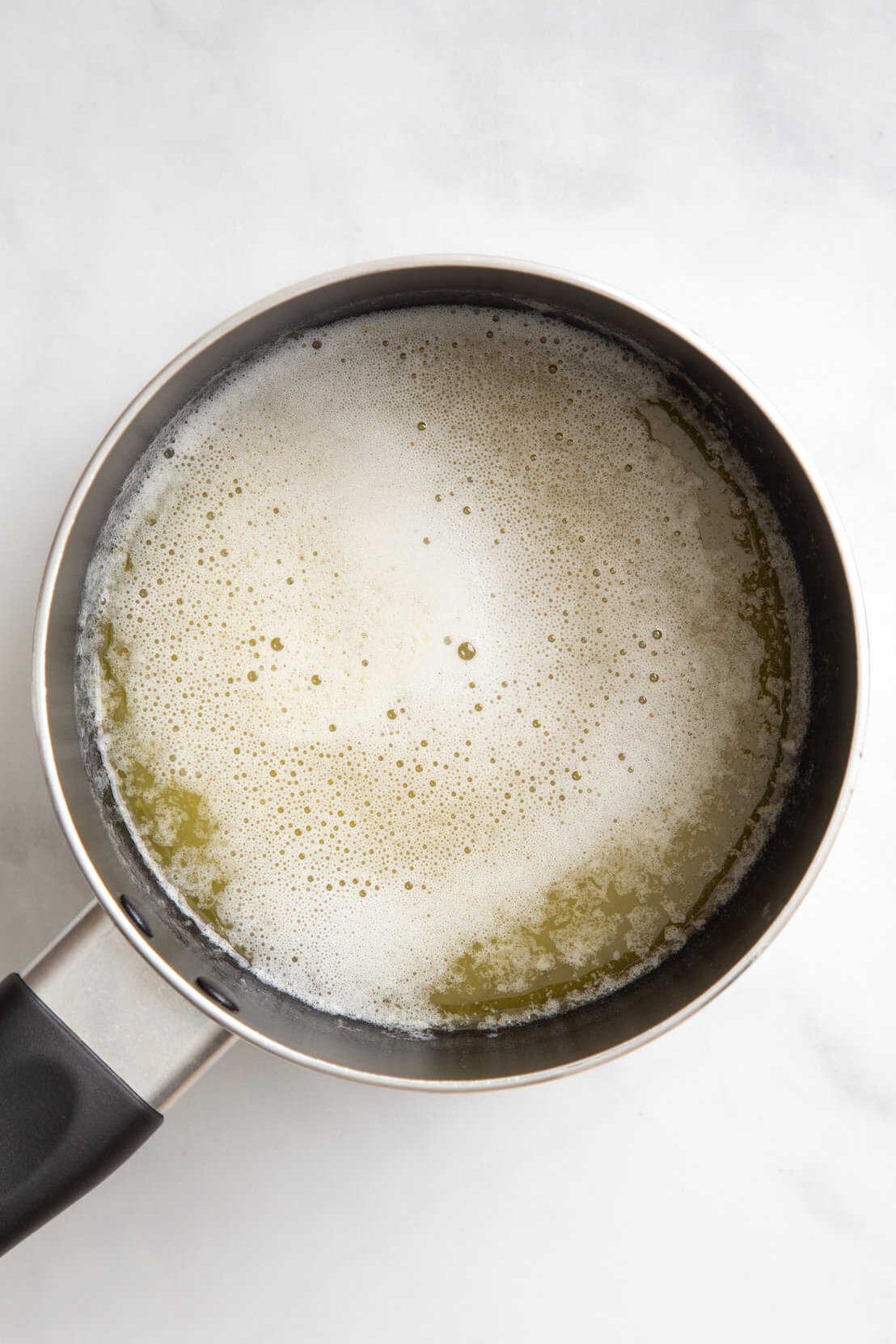 top down image of a sauce pan with melted butter. 
