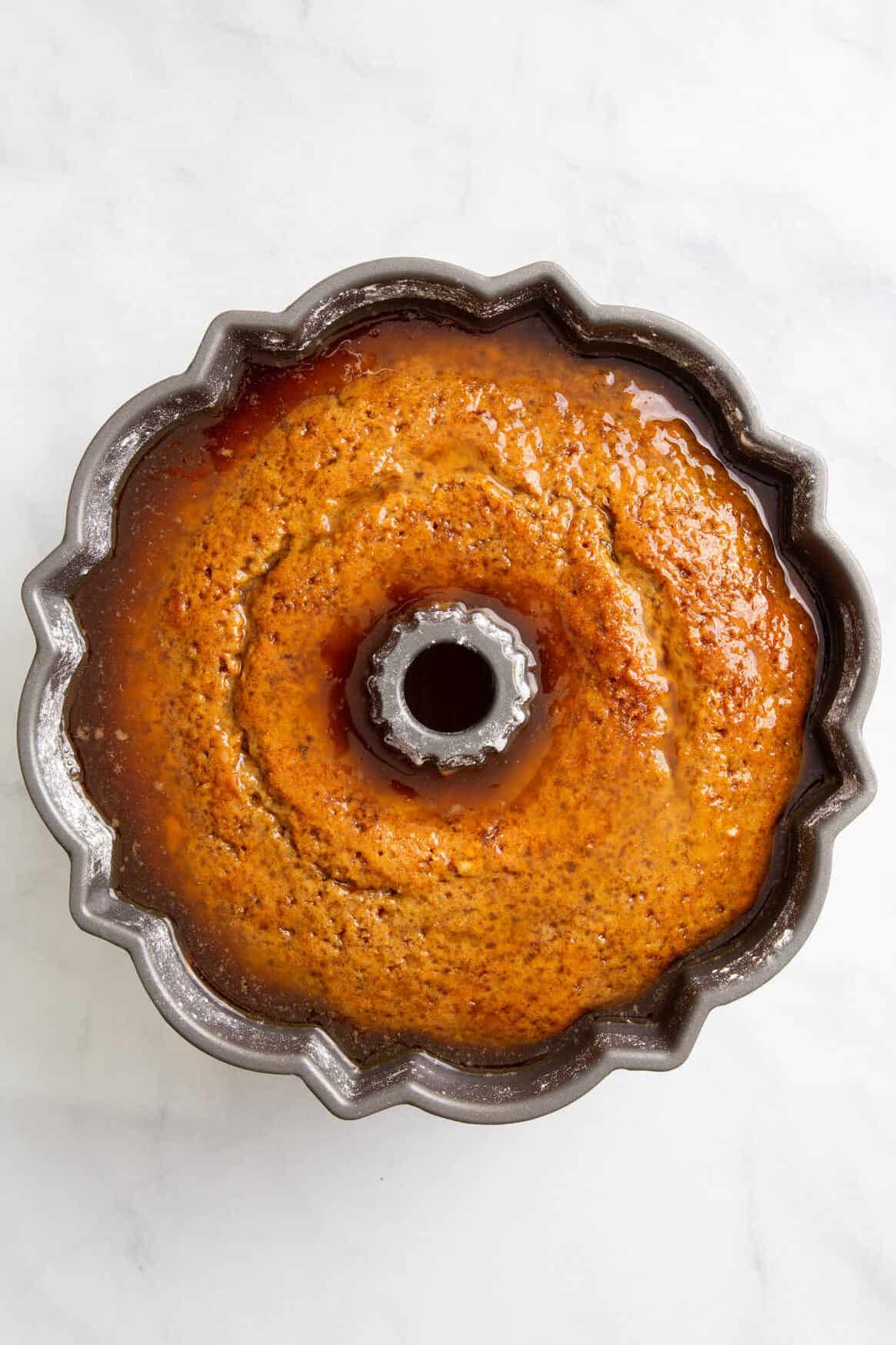 top down image of glazed crack cake in a bundt cake tin. 