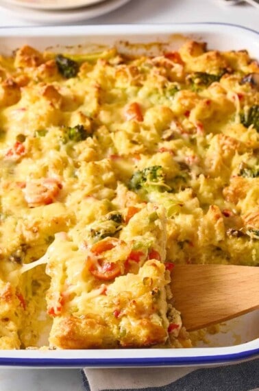 A wooden spoon lifting a scoop of vegetarian breakfast casserole.