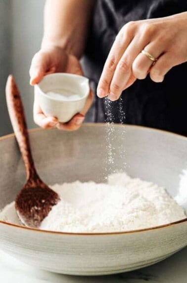 Salt being sprinkled in flour.