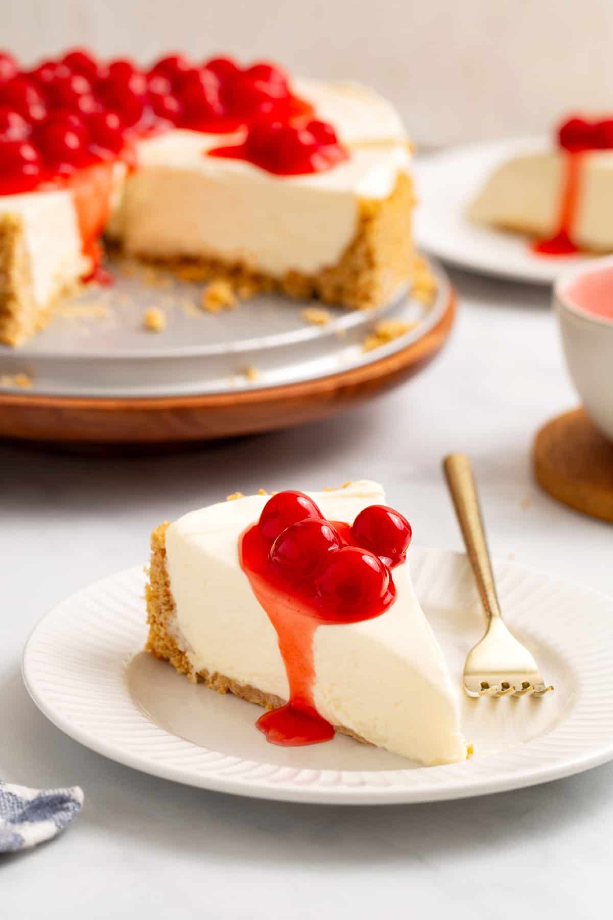 slice of philadelphia no bake cheesecake sitting on a white round plate. 