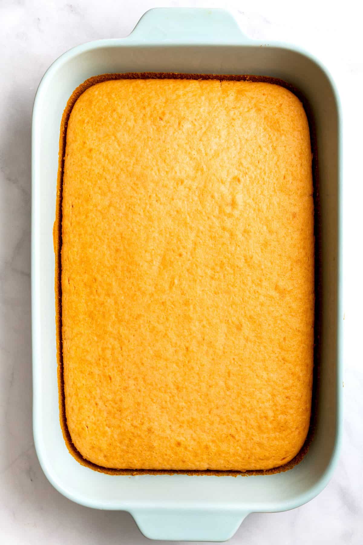 top down image of soda cake sitting in a 9x13 casserole baking dish. 