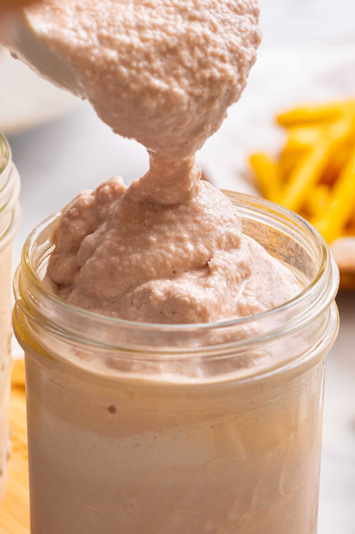 close up image of a mason jar of a homemade wendy's frosty with a silver spoon.