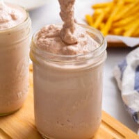 A homemade Frosty being poured into a mason jar.