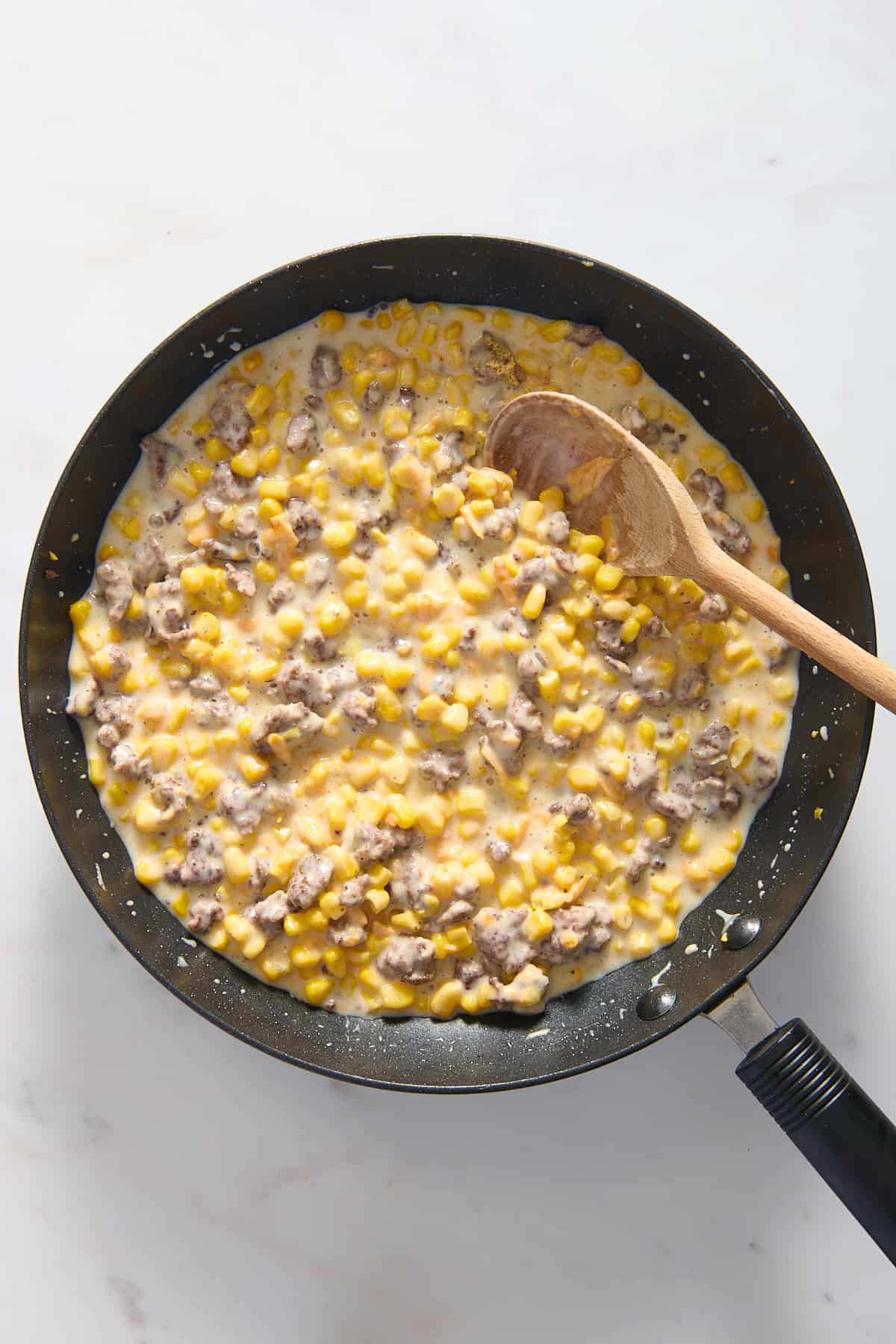 top down image of cowboy casserole filling cooking in a large skillet.