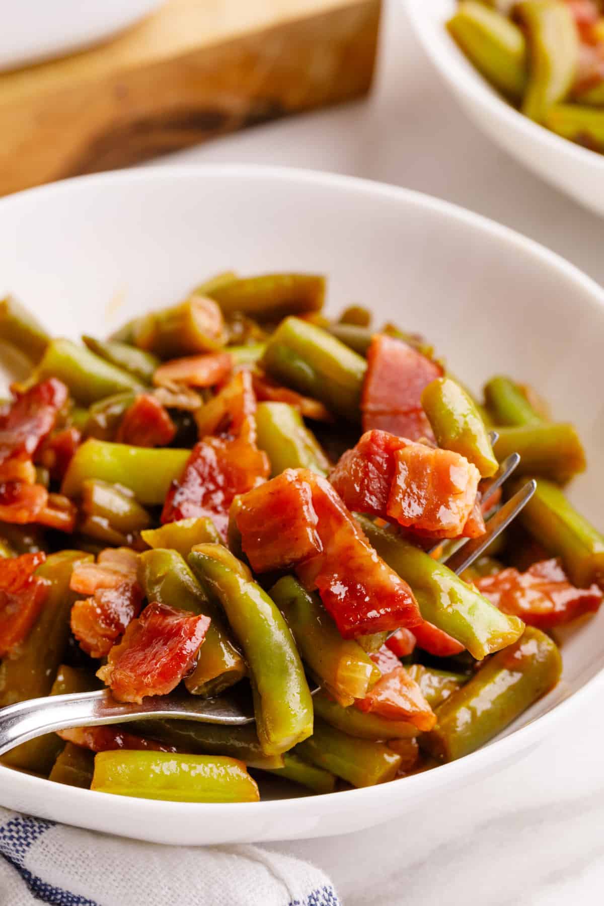 close up image of crack green beans served in a white round bowl. 