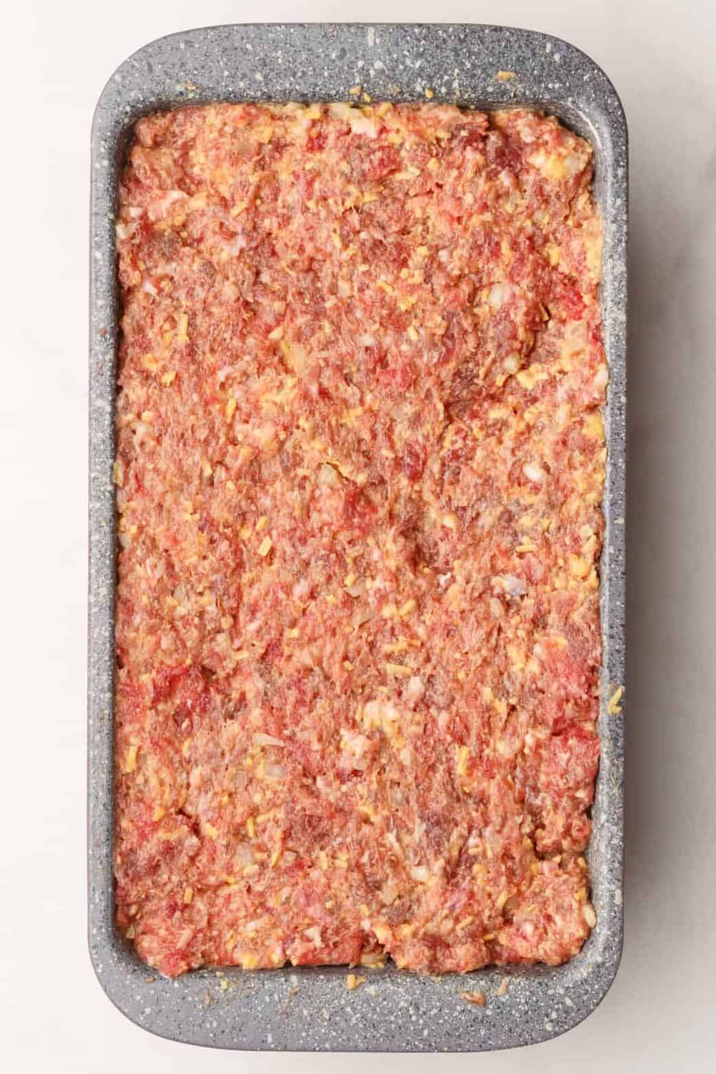 9x4 inch baking loaf pan with prepared cracker barrel meatloaf mixture.