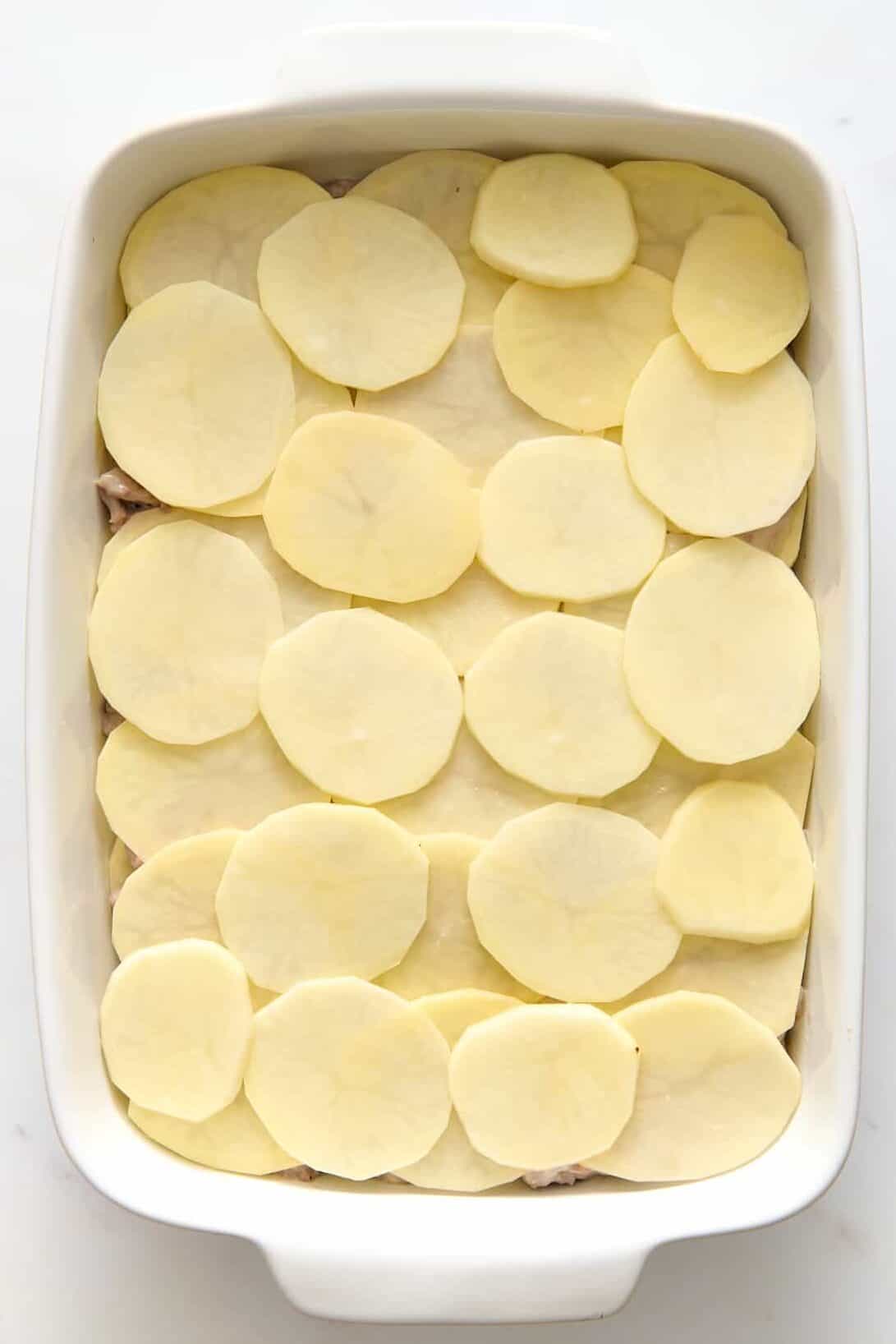 9x13 casserole dish with layered slices of potato. 