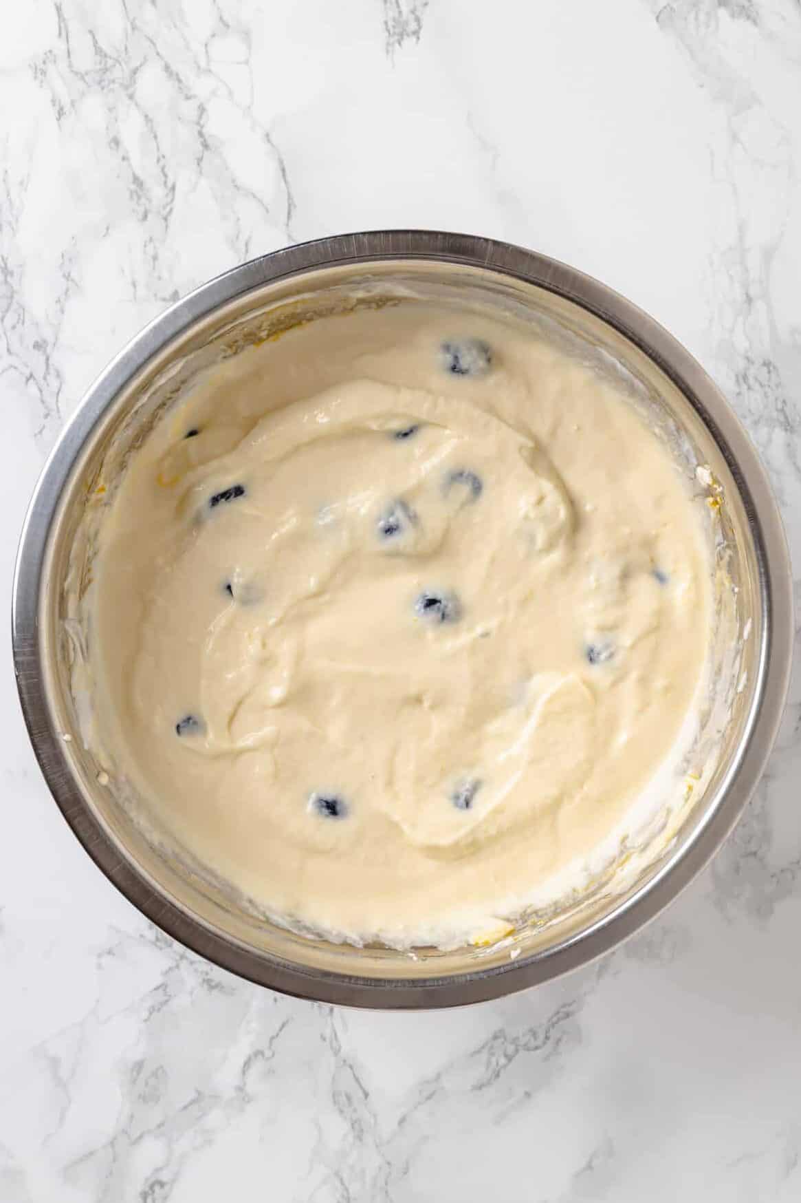 top down image Lemon Blueberry Cheesecake better sitting in a large stainless steel mixing bowl. 