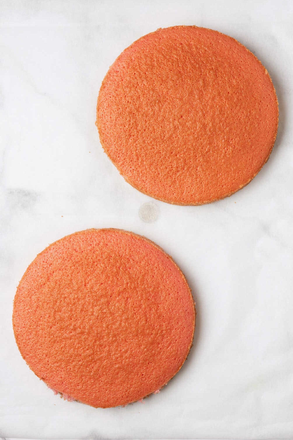 two round strawberry baked cakes.