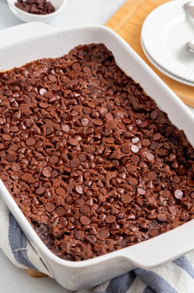 A baking dish full of chocolate dump cake topped with chocolate chips.