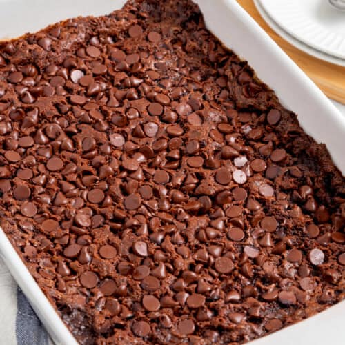 A baking dish full of chocolate dump cake topped with chocolate chips.