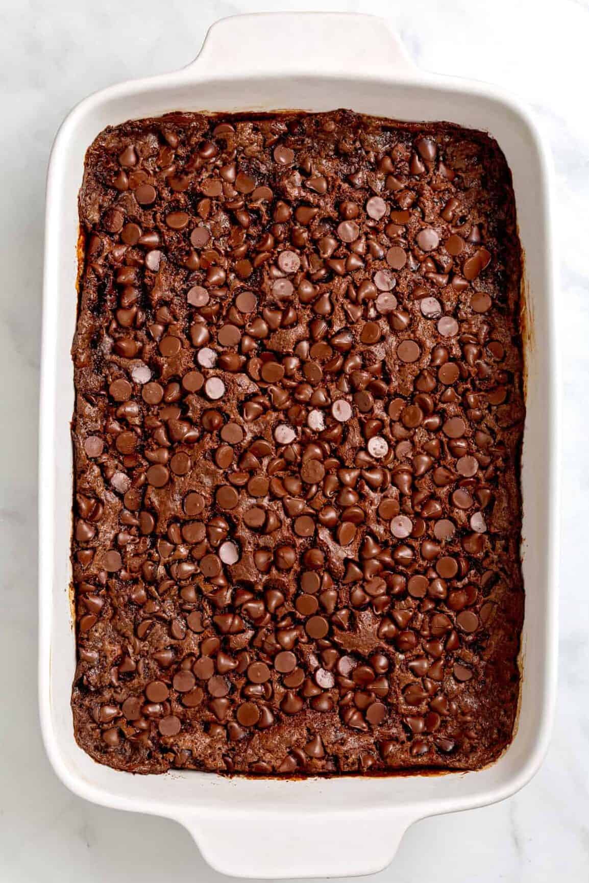 top down image of baked chocolate dump cake served in a 9x13 ceramic baking dish. 