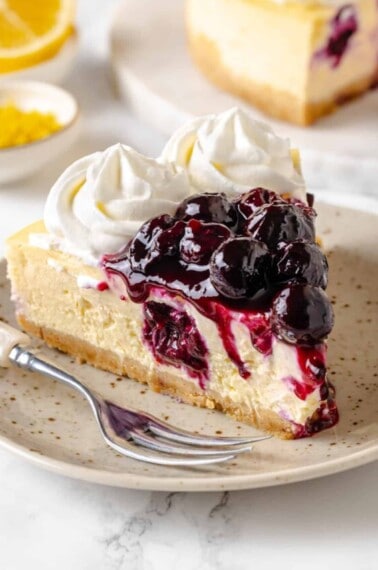 A slice of lemon blueberry cheesecake on a plate.