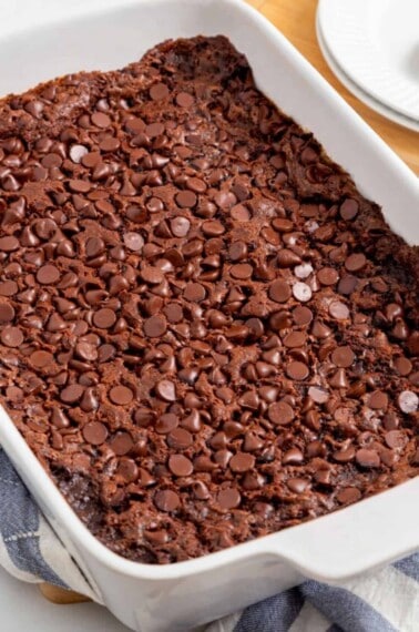 A baking dish full of chocolate dump cake topped with chocolate chips.
