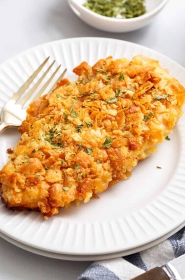A piece of Ritz cracker chicken on a plate with a fork.