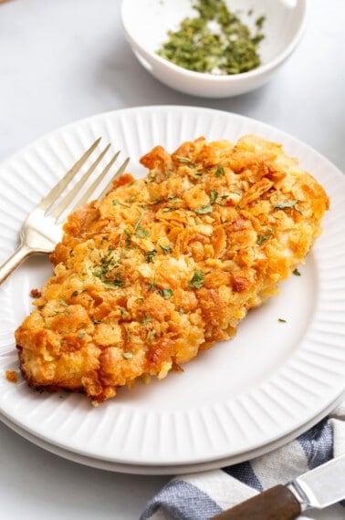 A piece of Ritz cracker chicken on a plate with a fork.