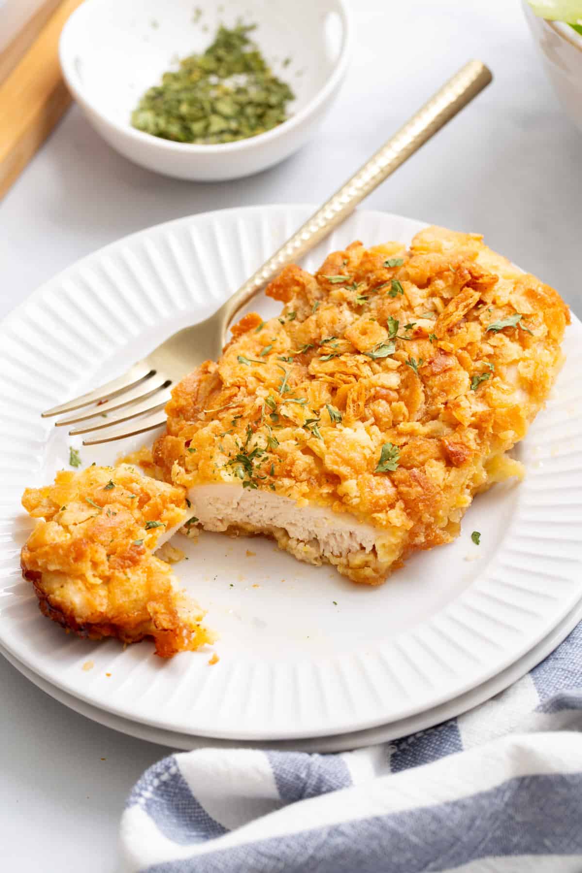 serving of rtiz cracker chicken cut in half to show the cross section and served on a round white plate. 