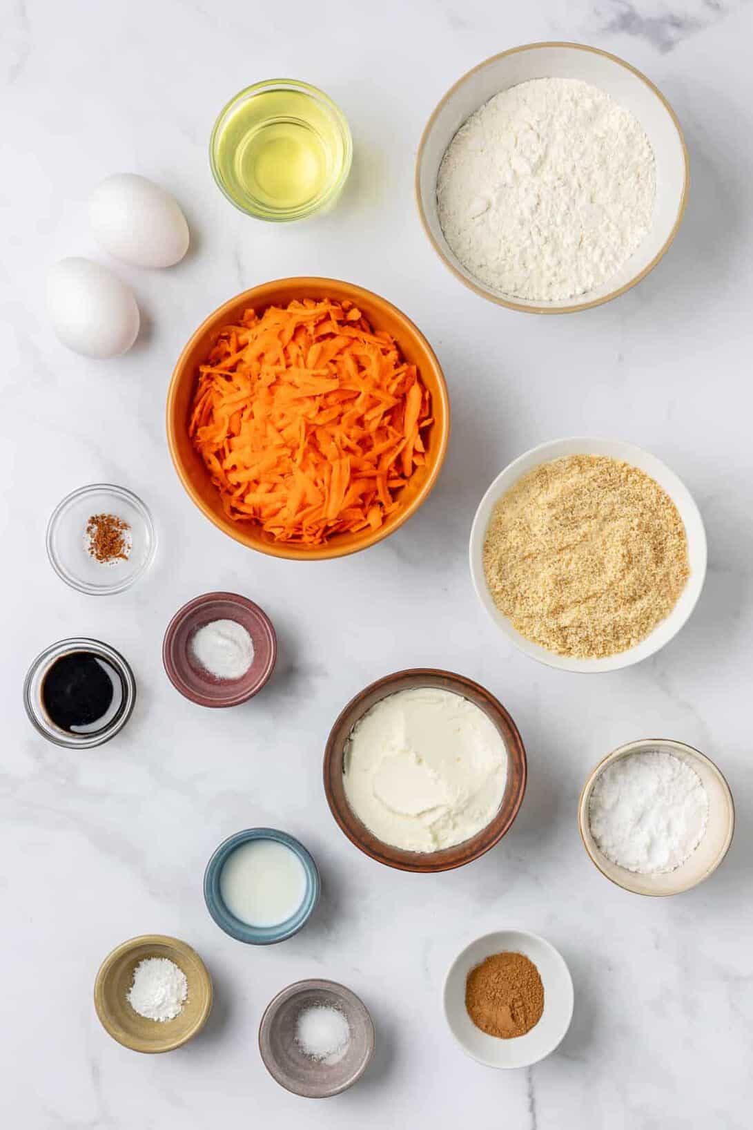 ingredients to make carrot cake muffins with cream cheese frosting.