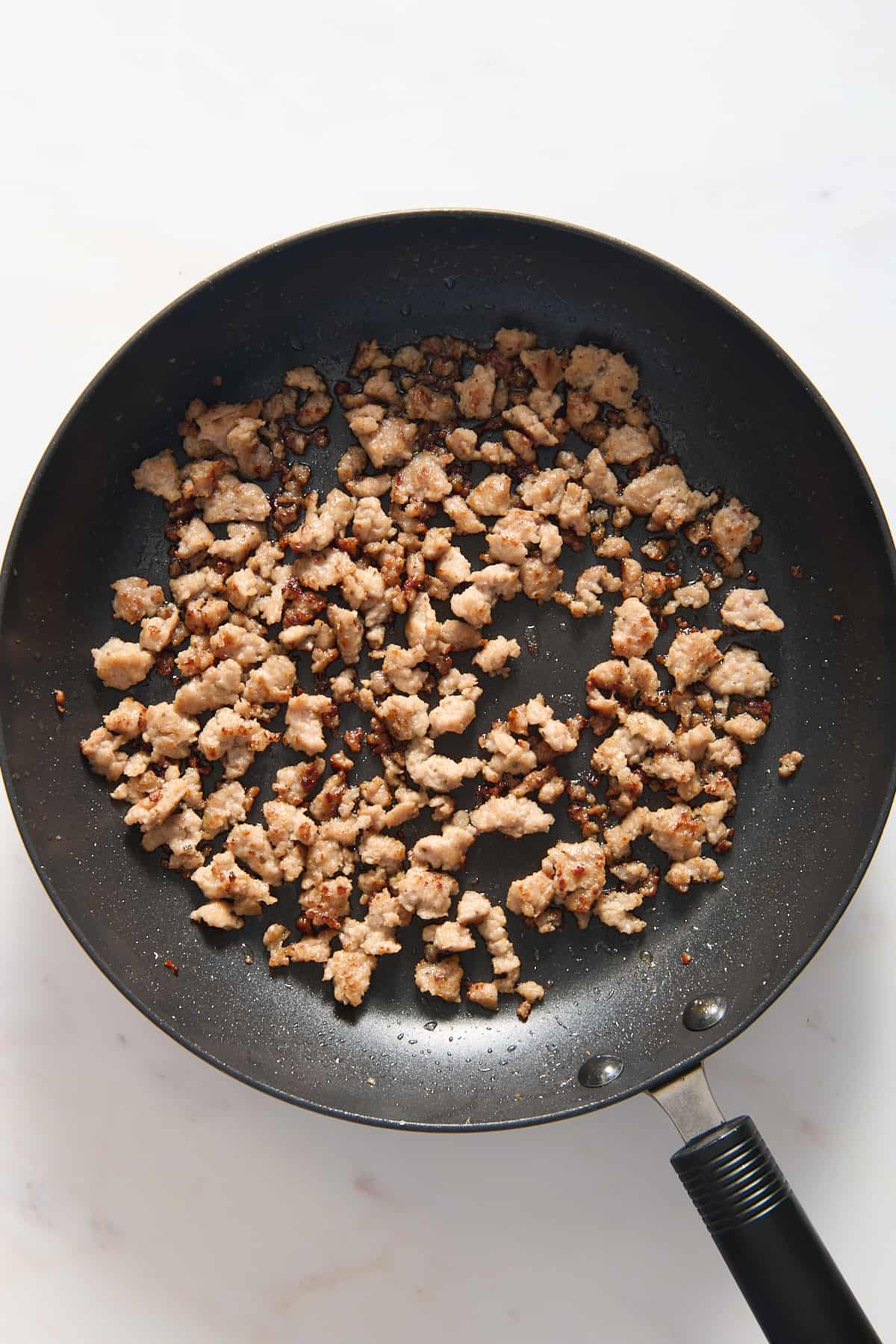 top down image of ground breakfast sausage in a large skillet. 