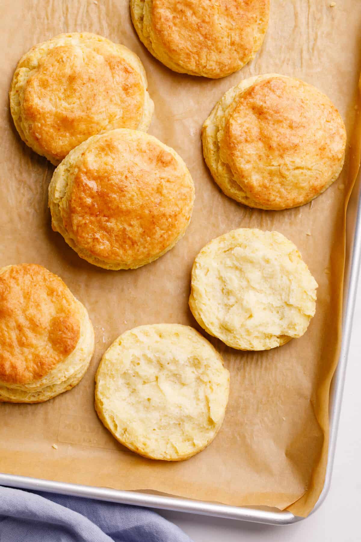 Top down image of Popeyes biscuits, sitting on a parchment lined baking tray.