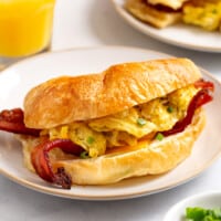 A croissant breakfast sandwich on a plate.