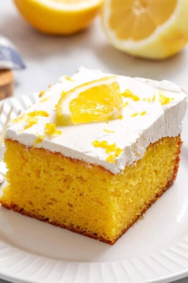 A slice of lemon poke cake on a plate.