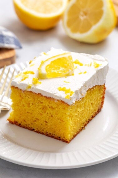 A slice of lemon poke cake on a plate.