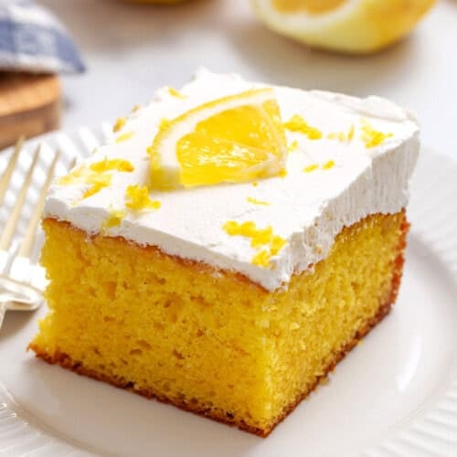 A slice of lemon poke cake on a plate.