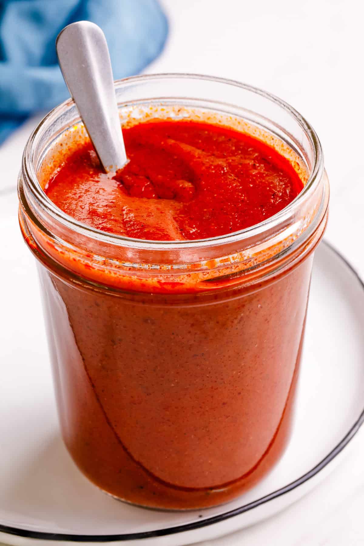 Close-up image of red enchilada sauce in a mason jar.