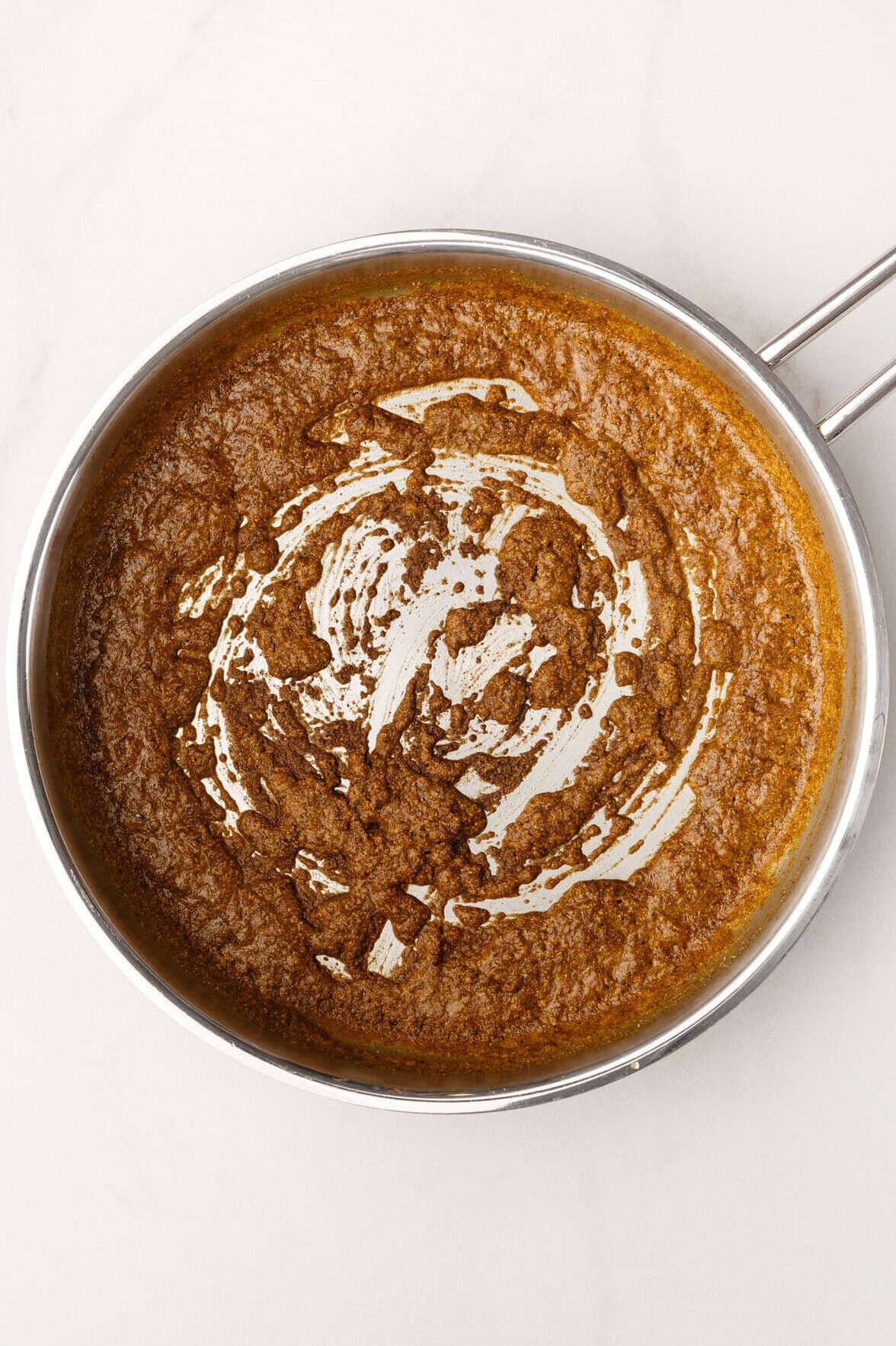 Top image of dry ingredients to make red enchilada sauce, and olive oil in a large skillet.