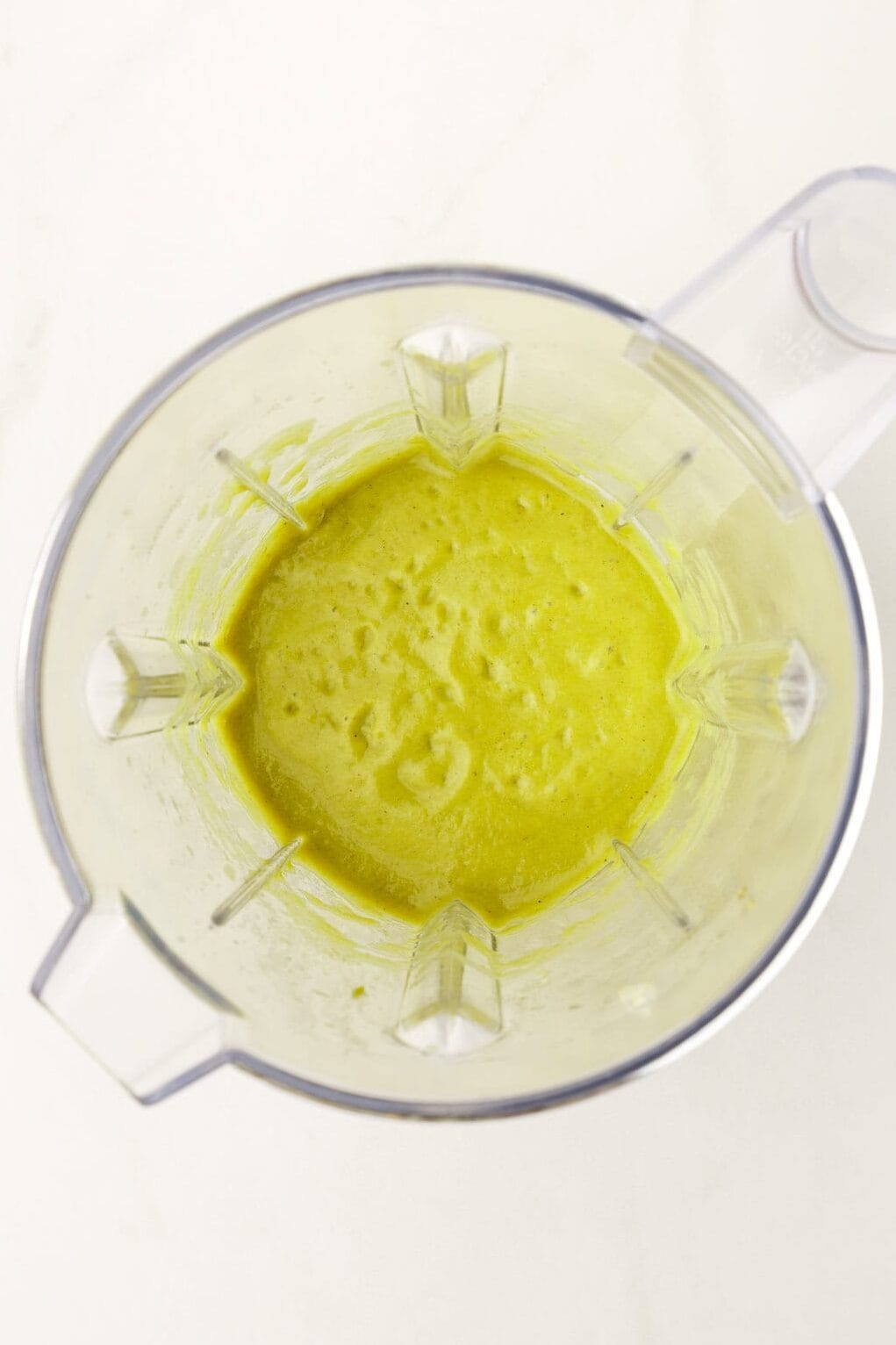 Top down image of homemade green enchilada sauce, sitting in a blender.