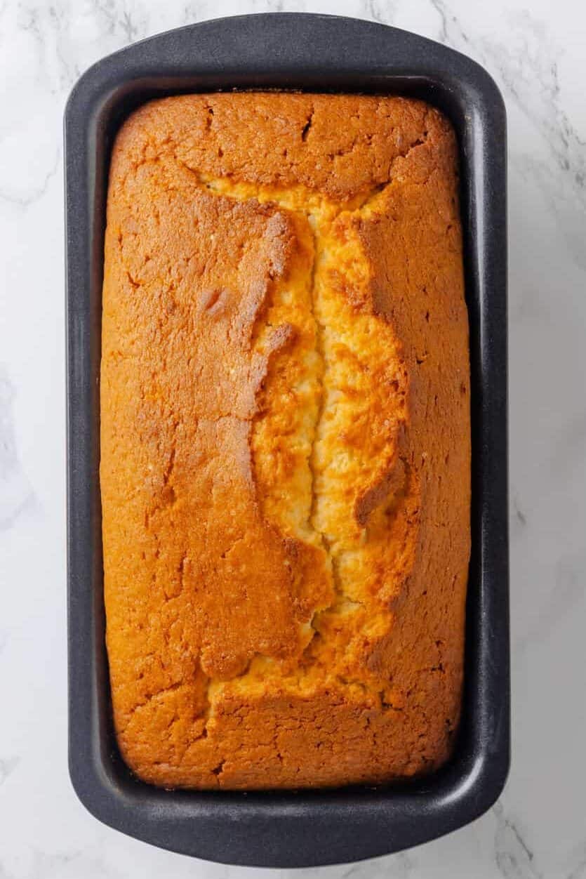 Image of baked lemon, poundcake sitting in a loaf baking pan.