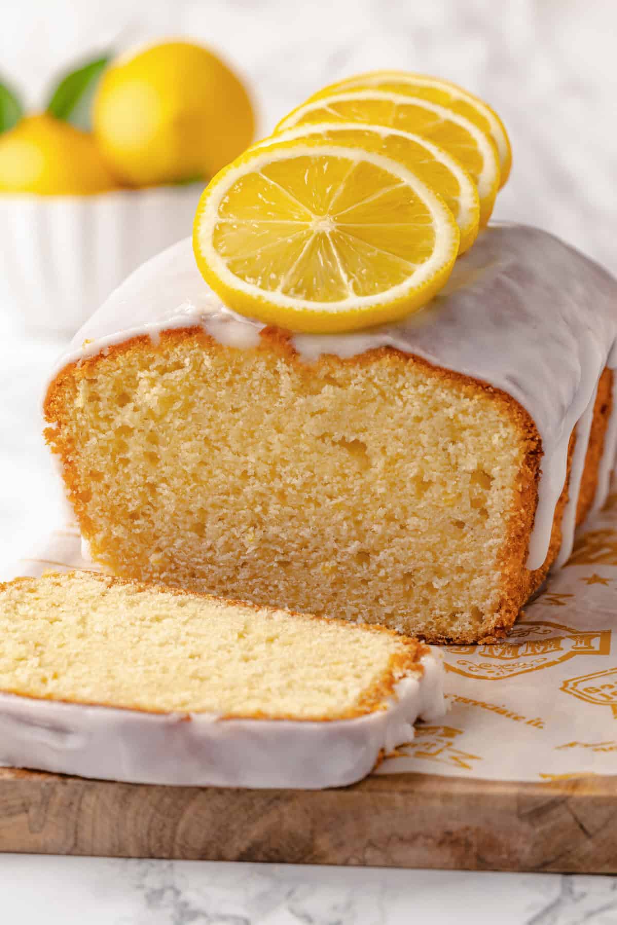 Close-up image of the cross-section of lemon pound cake sitting on a wood cutting board.