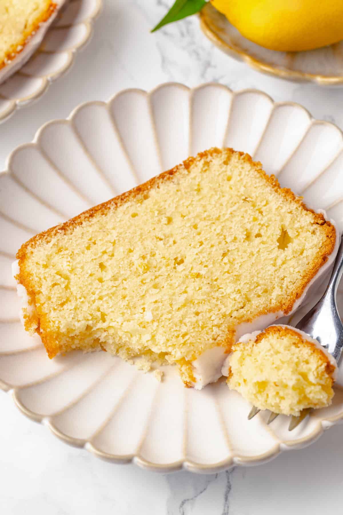 Top down image of a slice of lemon pound cake sitting on a decorative plate.