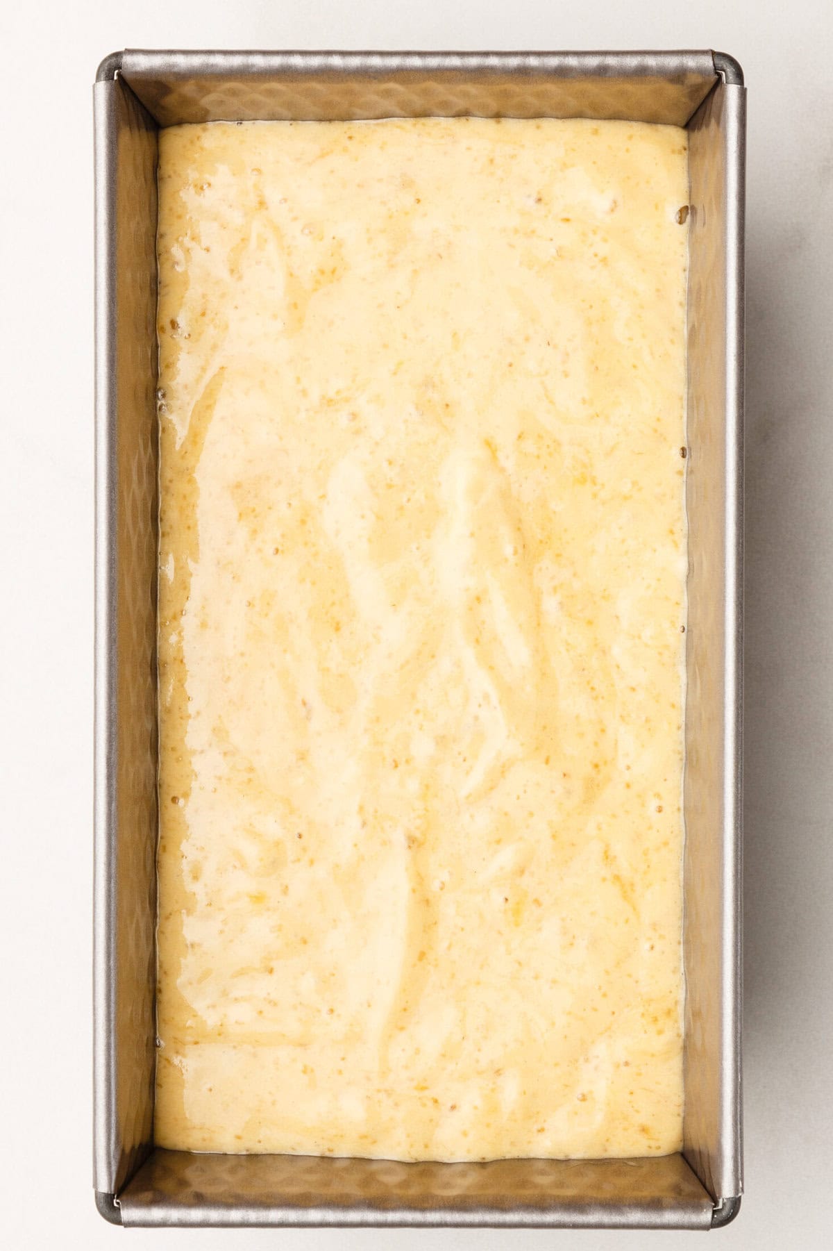 Metal loaf pan with 4-ingredient banana bread batter.