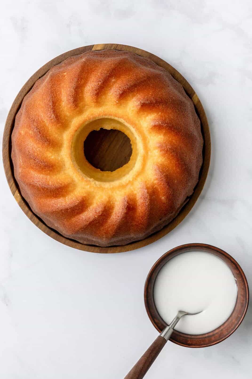 perfectly baked bundt cake sitting on a wooden platter.