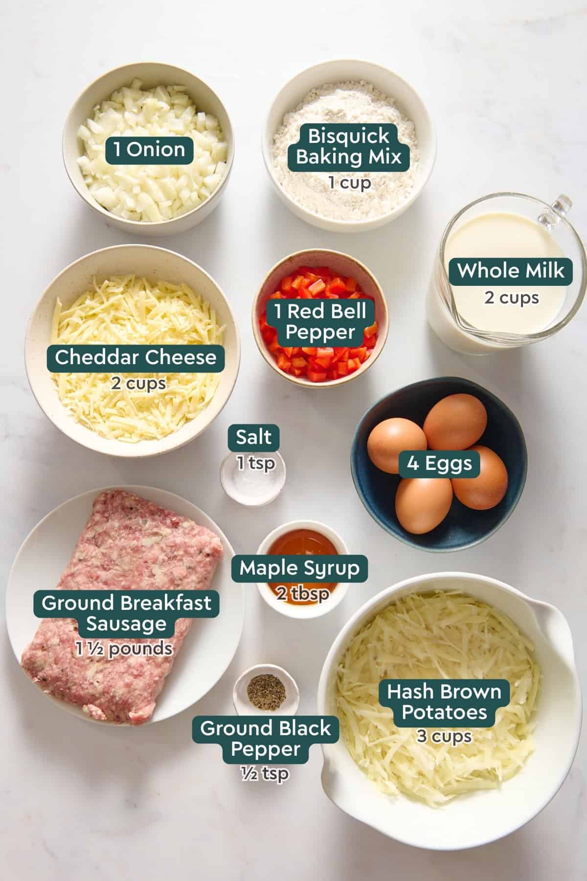 Ingredients for Bisquick breakfast casserole, including onion, Bisquick, red pepper, milk, cheese, eggs, salt, maple syrup, pepper, sausage, and hash browns.