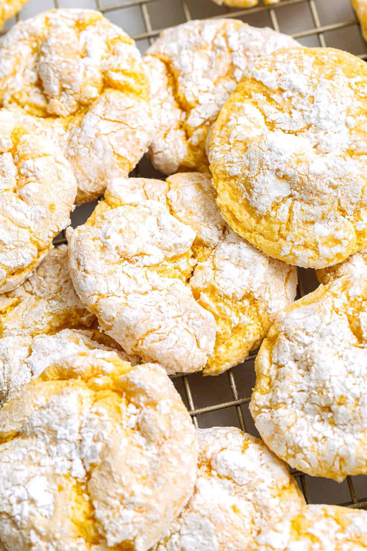 Close-up image of a pile of Cool Whip cake mix cookies sitting on a wire cooling rack.